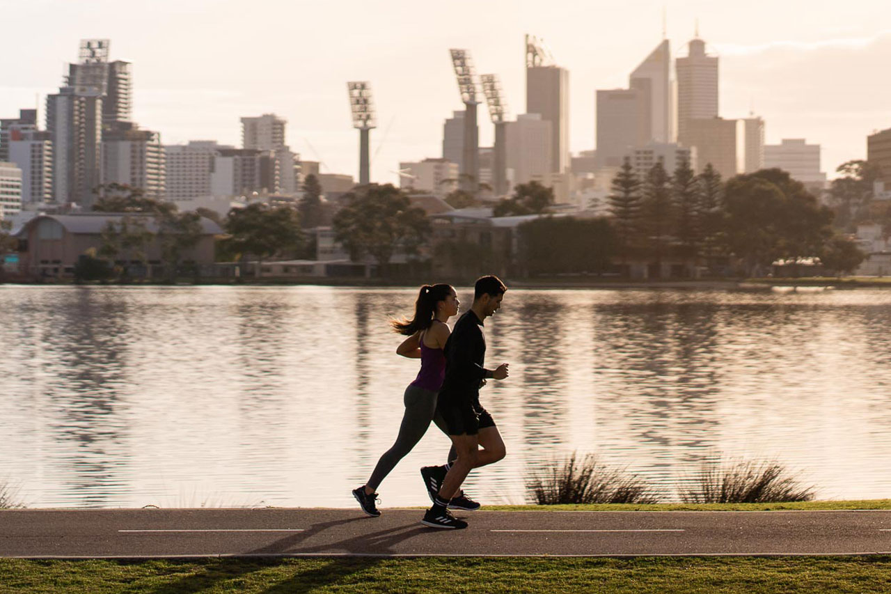 two runners enjoy a morning run along the Swan river two runners enjoy a morning run along the Swan river